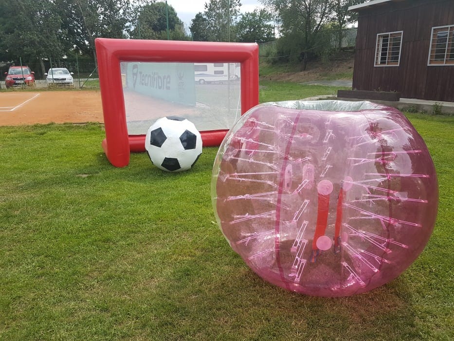 Hra na zahradě s fotbalovým míčem, nafukovacím balónem a sportovními prvky.